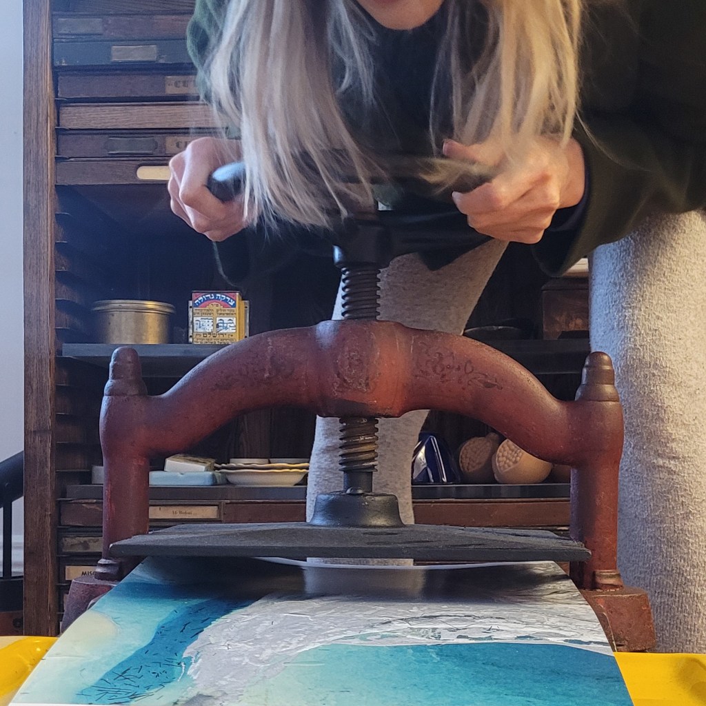 Woman making a flocked print with a hand press